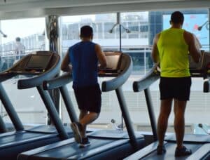 Modern gym with treadmills, people do sports on a cruise ship, view from the back. MSC Meraviglia