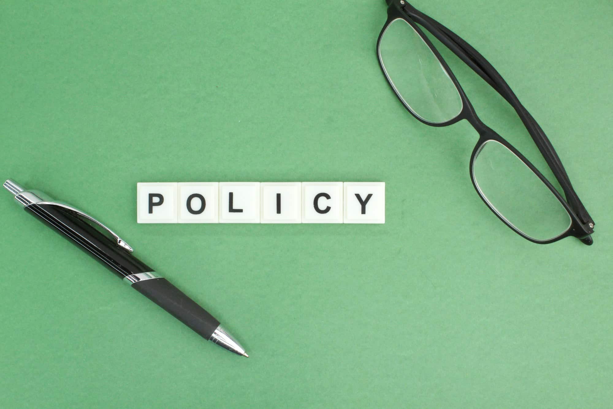 pen and glasses with the word Policy.